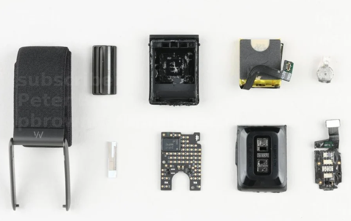 WHOOP 5.0 strap disassembled into its components: band, battery, optical sensor, mainboard, and housing
